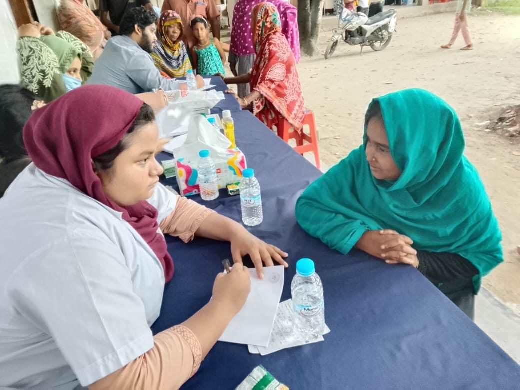 A medical professional in consultation with a woman from the village